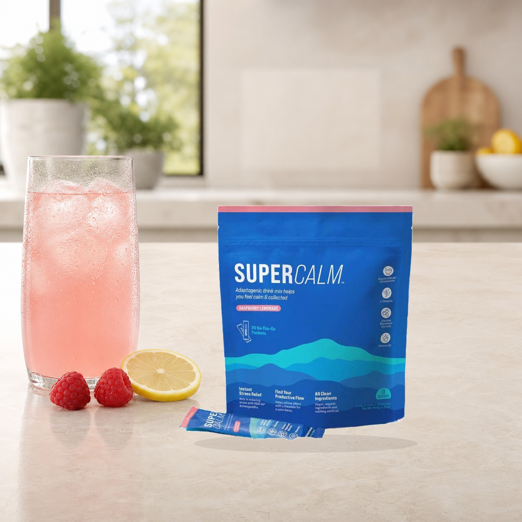 SUPRACALM Raspberry Lemonade drink mix with a prepared pink drink, raspberries, and lemon